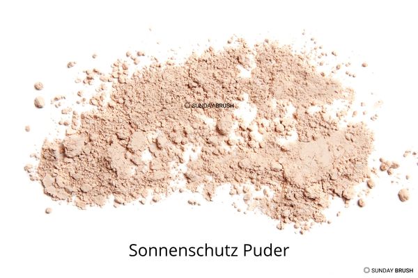 Mineralischer Sonnenschutz Puder wird mit einem Pinsel auf das Gesicht aufgetragen